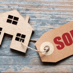 House model with a sold tag representing selling a house