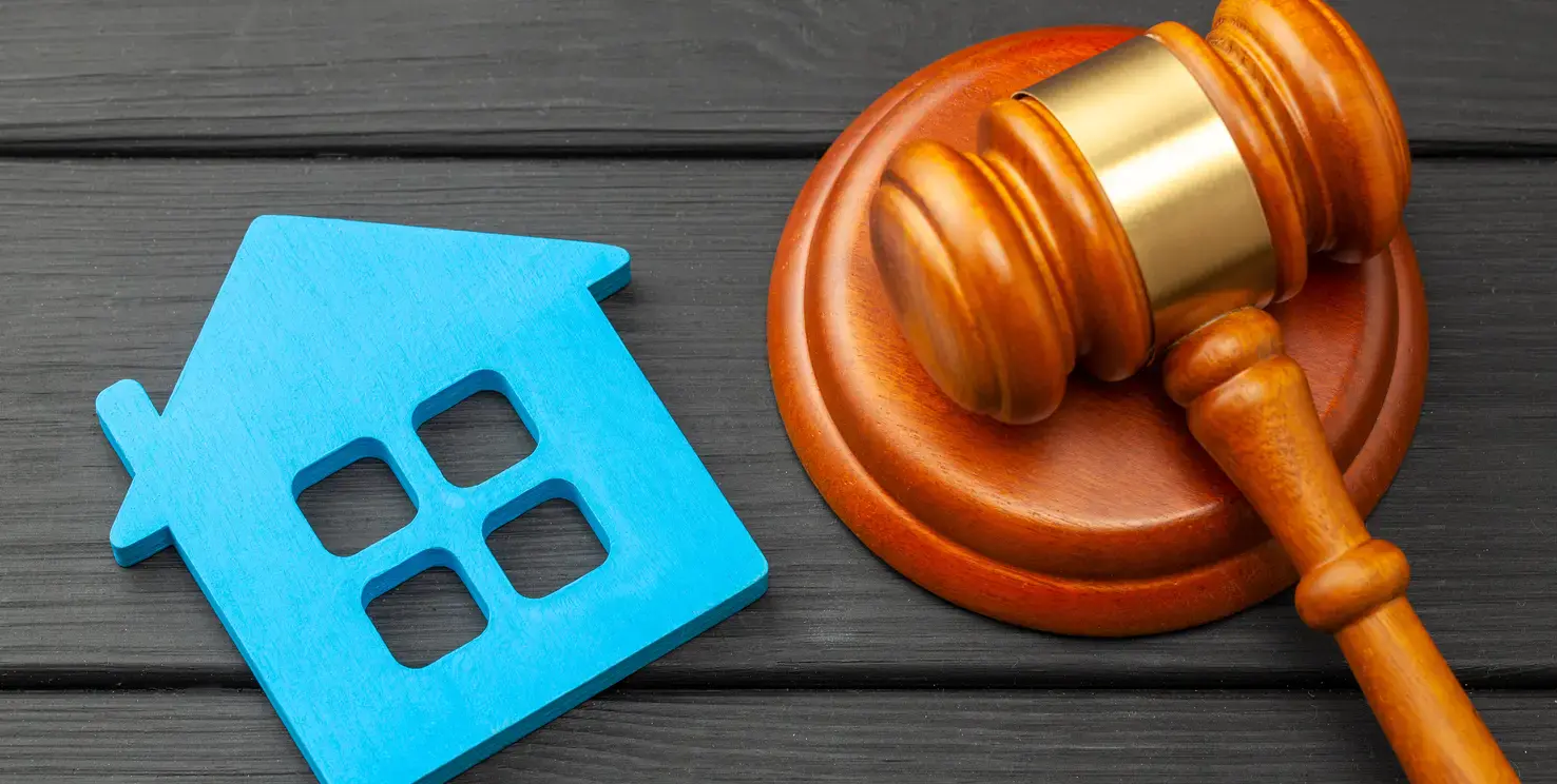 House icon beside a judge’s gavel, representing selling a house after a divorce