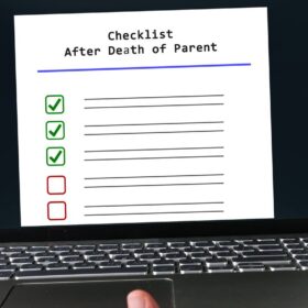 Person holding a laptop displaying a checklist for selling a home after the death of a parent.